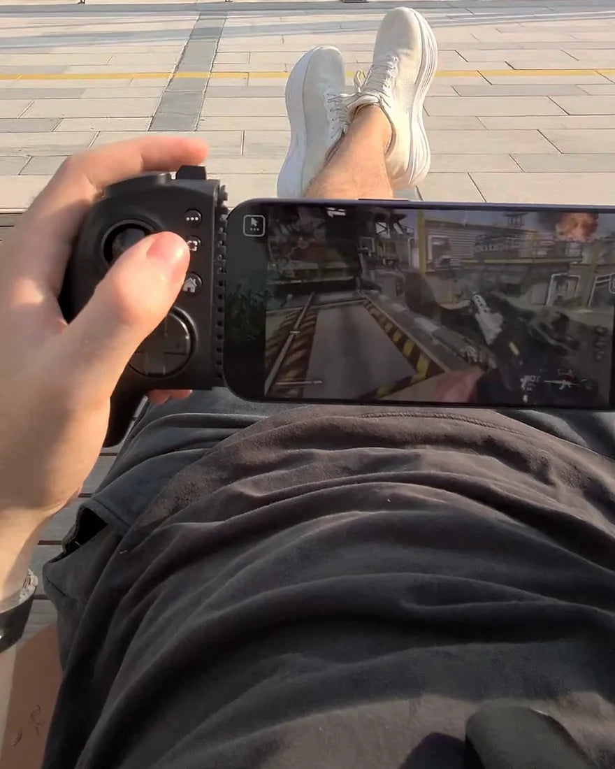 Le pouce gauche appuie sur le bouton capture d’Osyn Pro, une partie à l’écran du téléphone